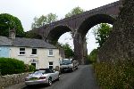 Painted cottages, towered over by a viaduct