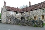 Frontage of a stone built house with a blue plaque
