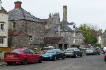 Stone houses, an old ston ebuilt mill with a tall chimney, and distant church