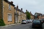 Terrace of older brown-sandstone buildings receding into the distance