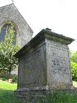 Chest tomb, viewed from a low angle, with the church behind
